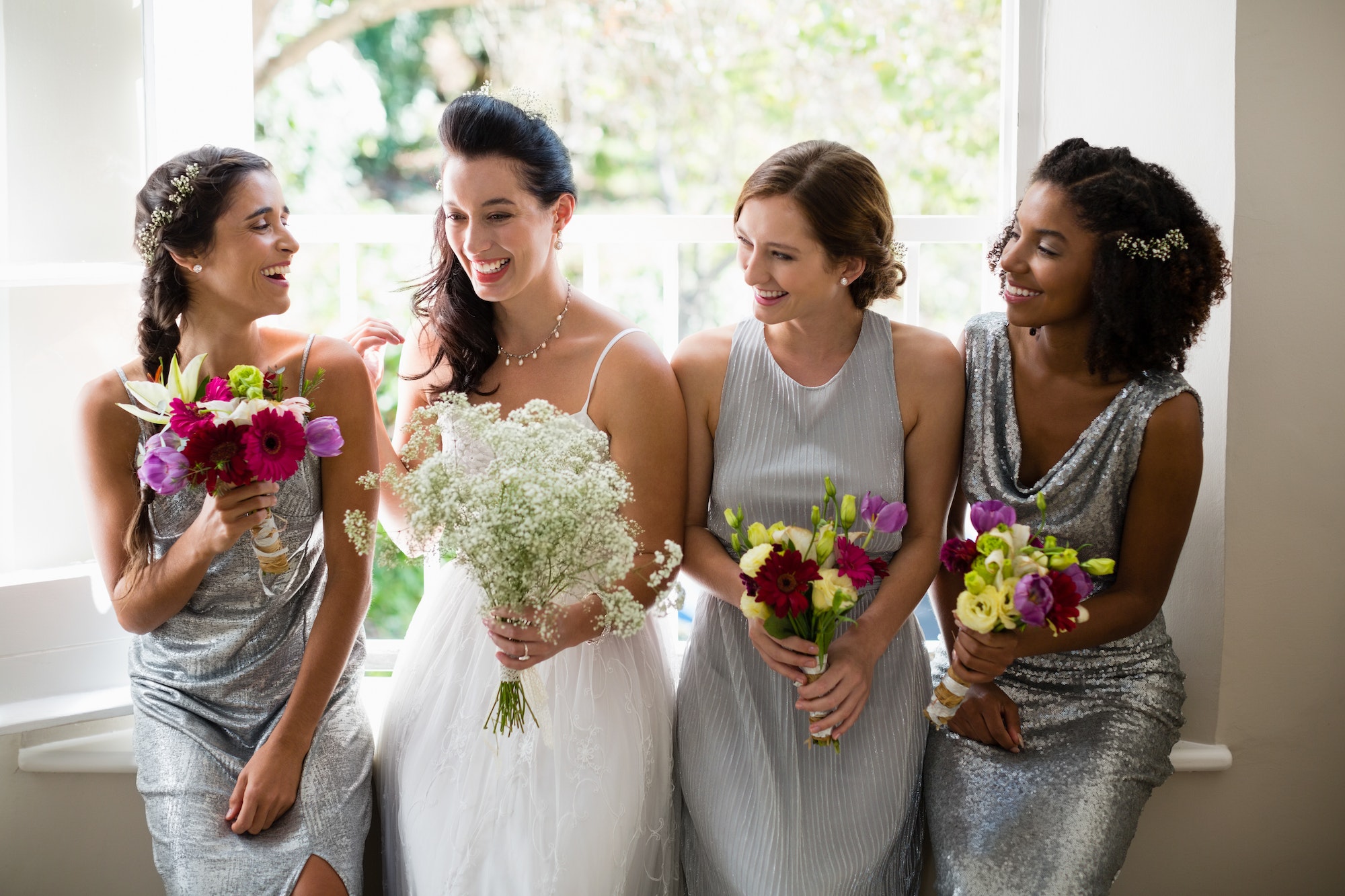 Bride and bridesmaids standing with bouquet TranscenDental Smiles provides Teeth Whitening Services