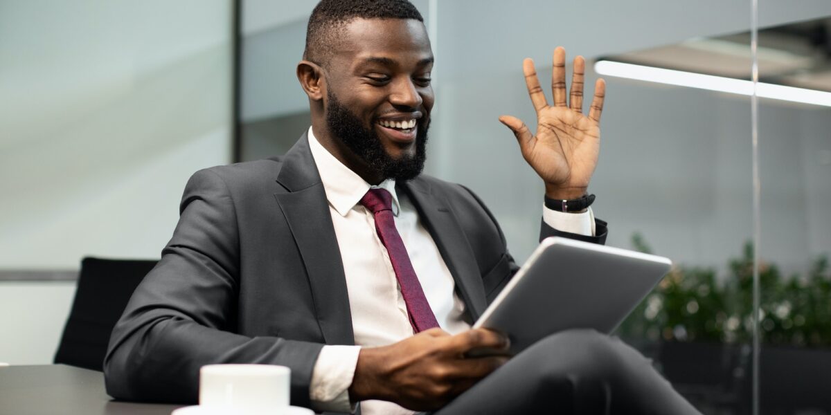 Happy black businessman having video chat, using digital tablet TranscenDental Smiles offers ROOT CANAL TREATMENT