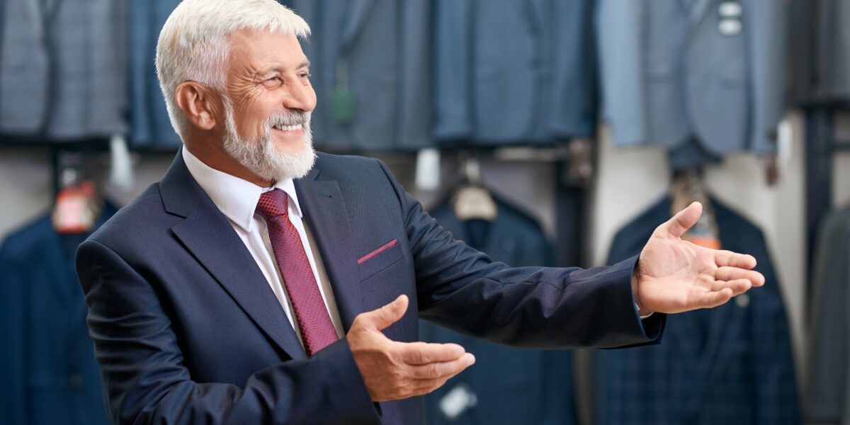 Older man smiling choosing costumes in store Select TranscenDental Smiles Texas as your restorative dentistry service
