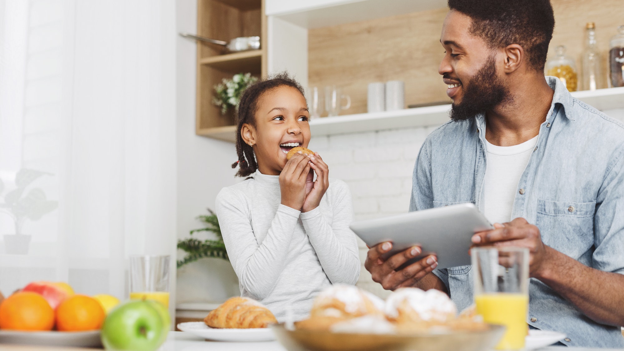 Father and daughter eating sweets and looking for new recipes ( not a patient that uses tooth fillings)