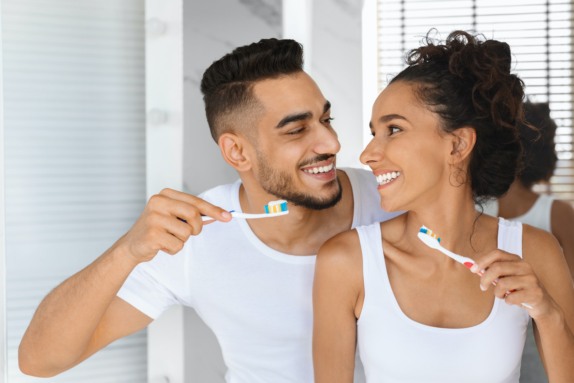 Happy Beautiful Arab Couple Making Morning Hygiene, Brushing Teeth Together In Bathroom TranscenDental Smiles offers professional teeth cleanings